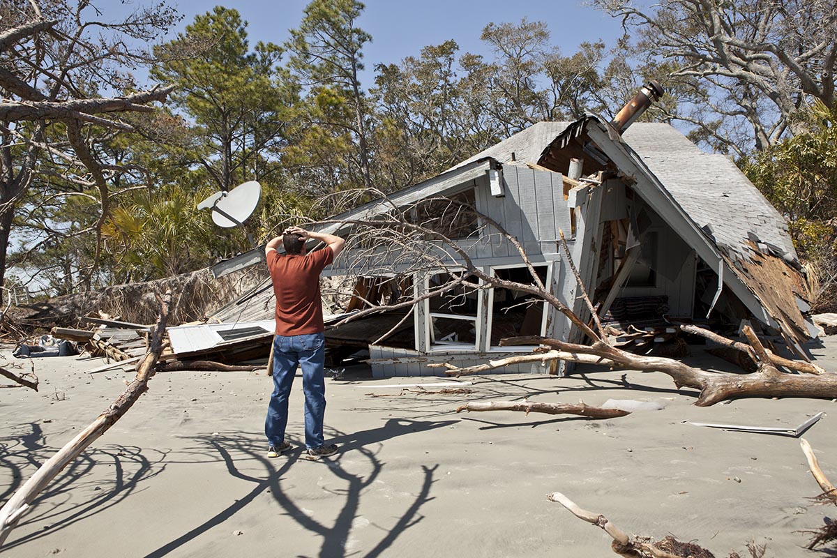 man stands near his destroyed home without a disaster-ready checklist to support his recovery | Corporate Synergies