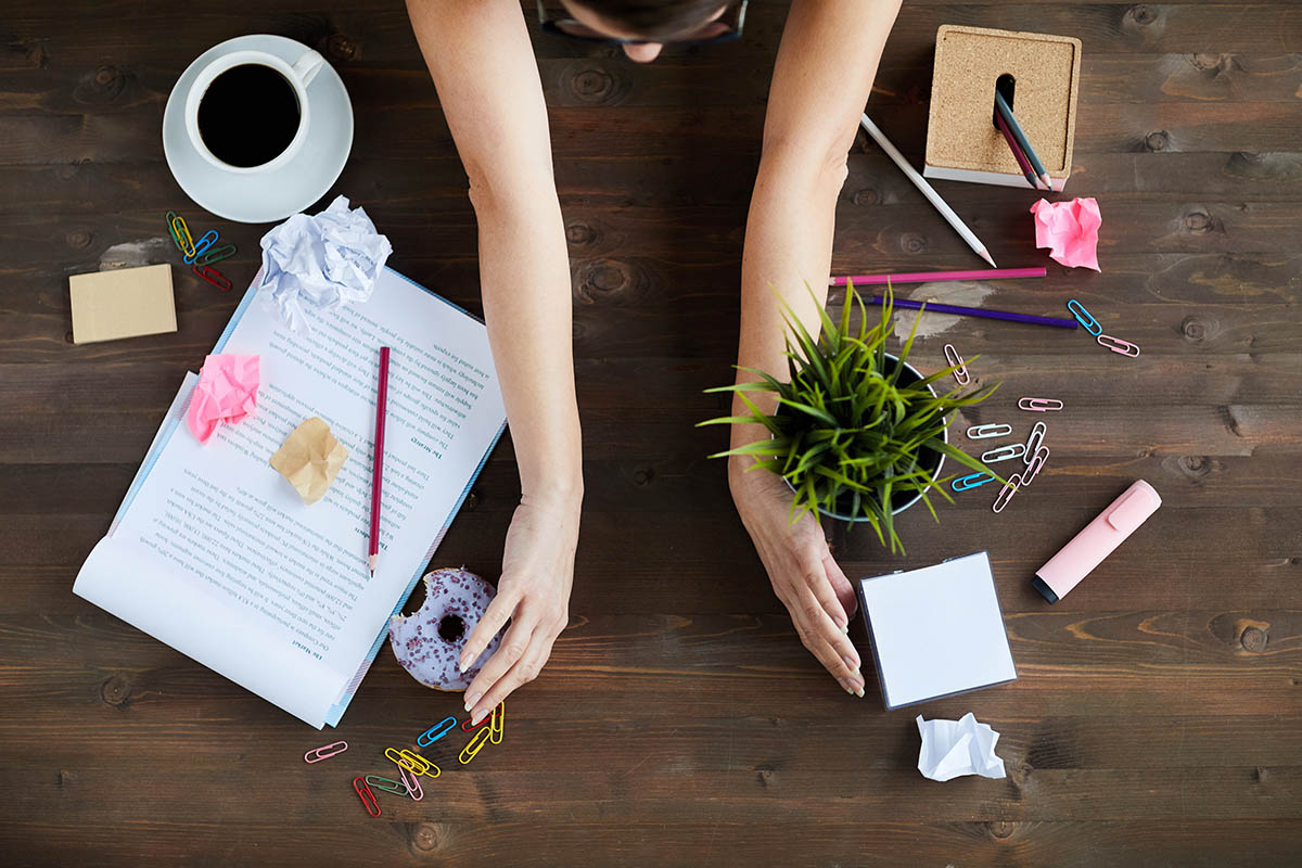 overhead view of a woman spring cleaning her office desk |Corporate Synergies