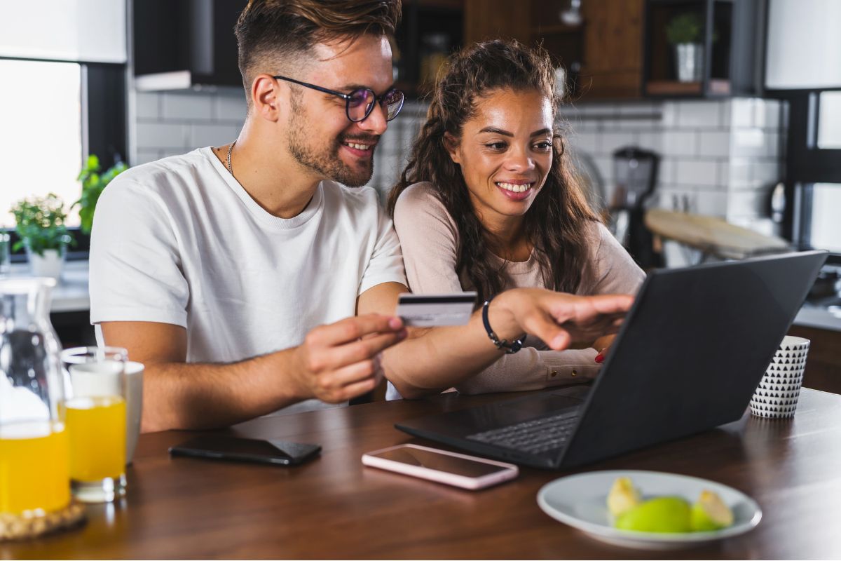 a smiling couple examines the flexible benefits offered by an employer on a laptop| Corporate Synergies