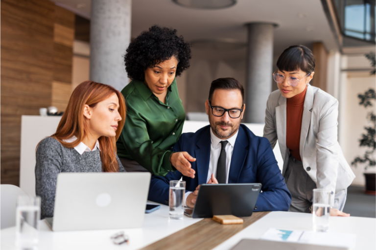 HR team huddles around laptop trying to understand the mystery of their benefits renewal| Corporate Synergies