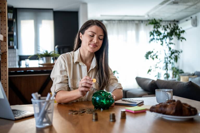 An employee demonstrates her financial literacy by saving money in a piggy bank |Corporate Synergies