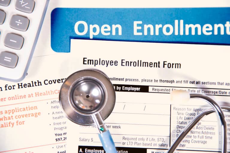 A stethoscope sits atop forms employees need to review during the open enrollment window |Corporate Synergies