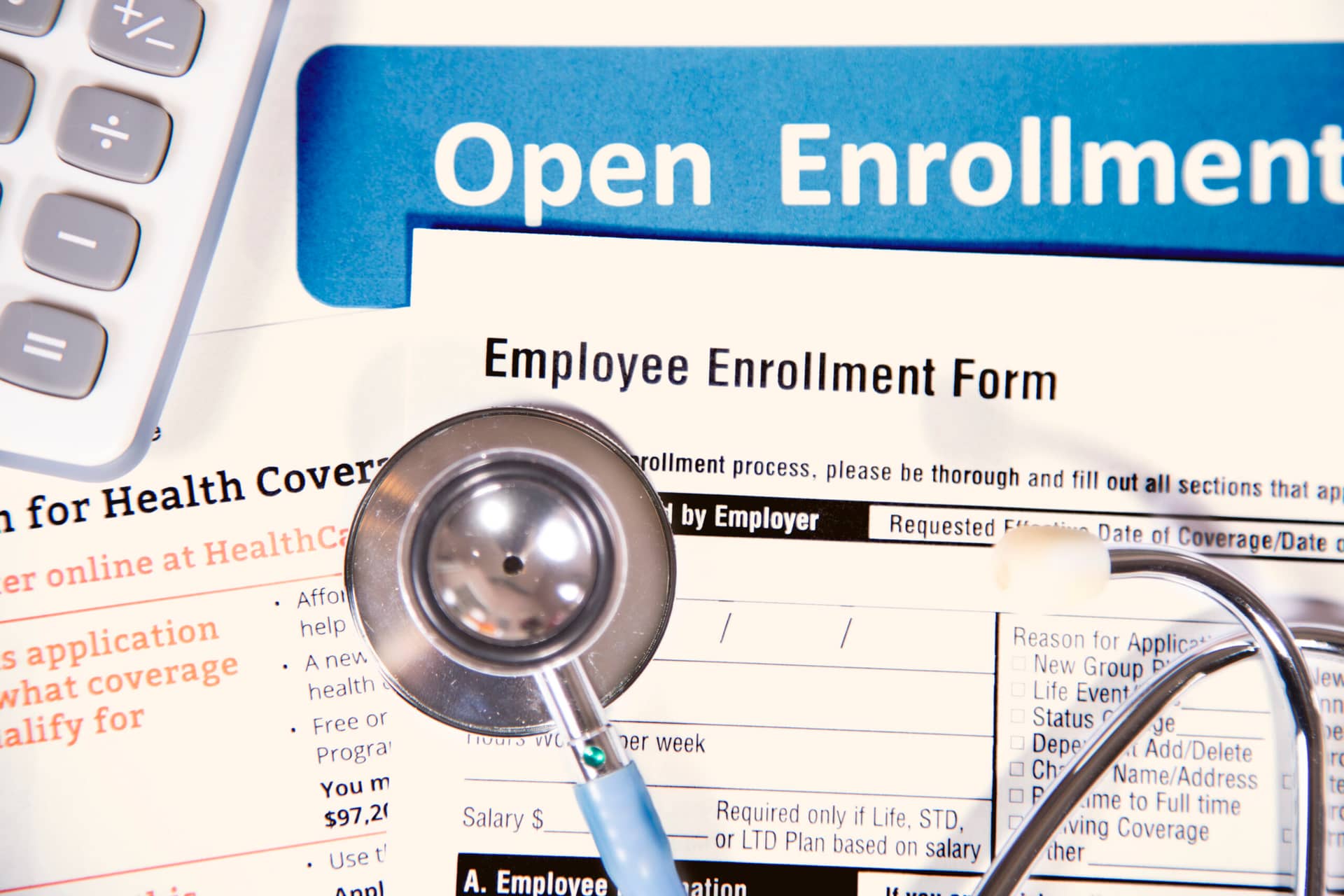 A stethoscope sits atop forms employees need to review during the open enrollment window |Corporate Synergies